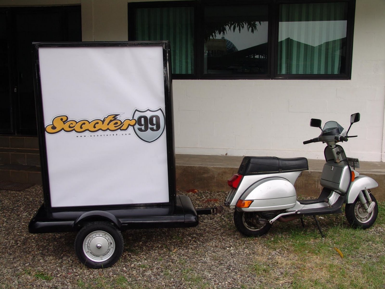 Media advertising trailer attached to Vespa for street marketing
